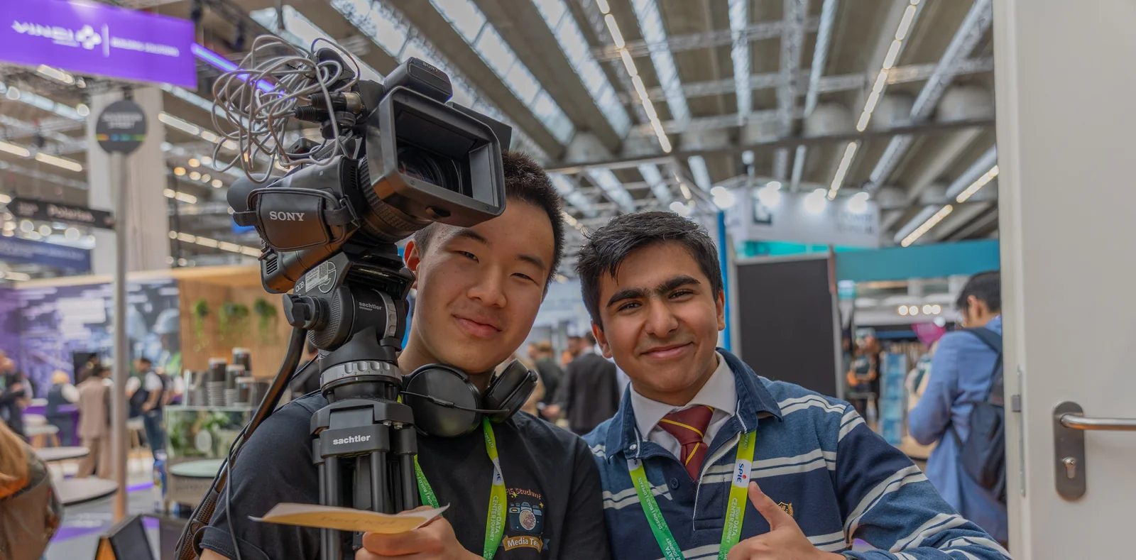 Two FIS student media team members with a video camera at the Frankfurt Tech Show